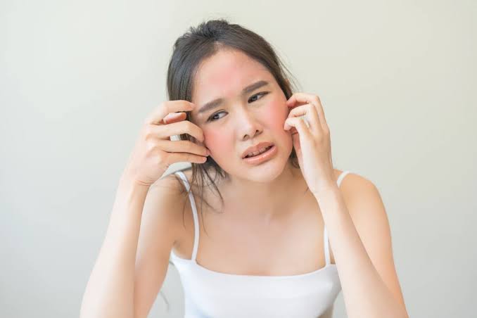 Woman touching her cheek showing sensitive skin considerations for facial waxing