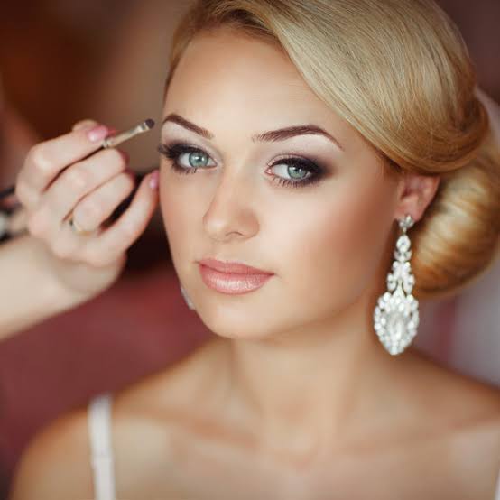 Makeup artist applying bridal eye makeup for a long-lasting wedding lash look
