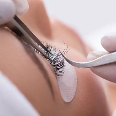Kỹ thuật viên đang nối mi cho khách hàng bằng nhíp chuyên dụng